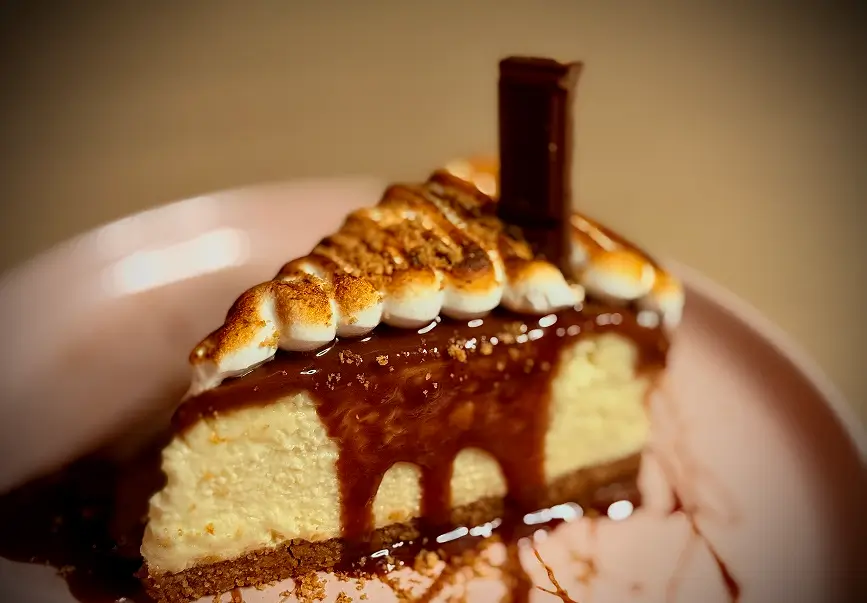 S’mores Cheesecake topped with torched marshmallow, chocolate fudge, and graham cracker crust – a Rockwell & Rose signature dessert.